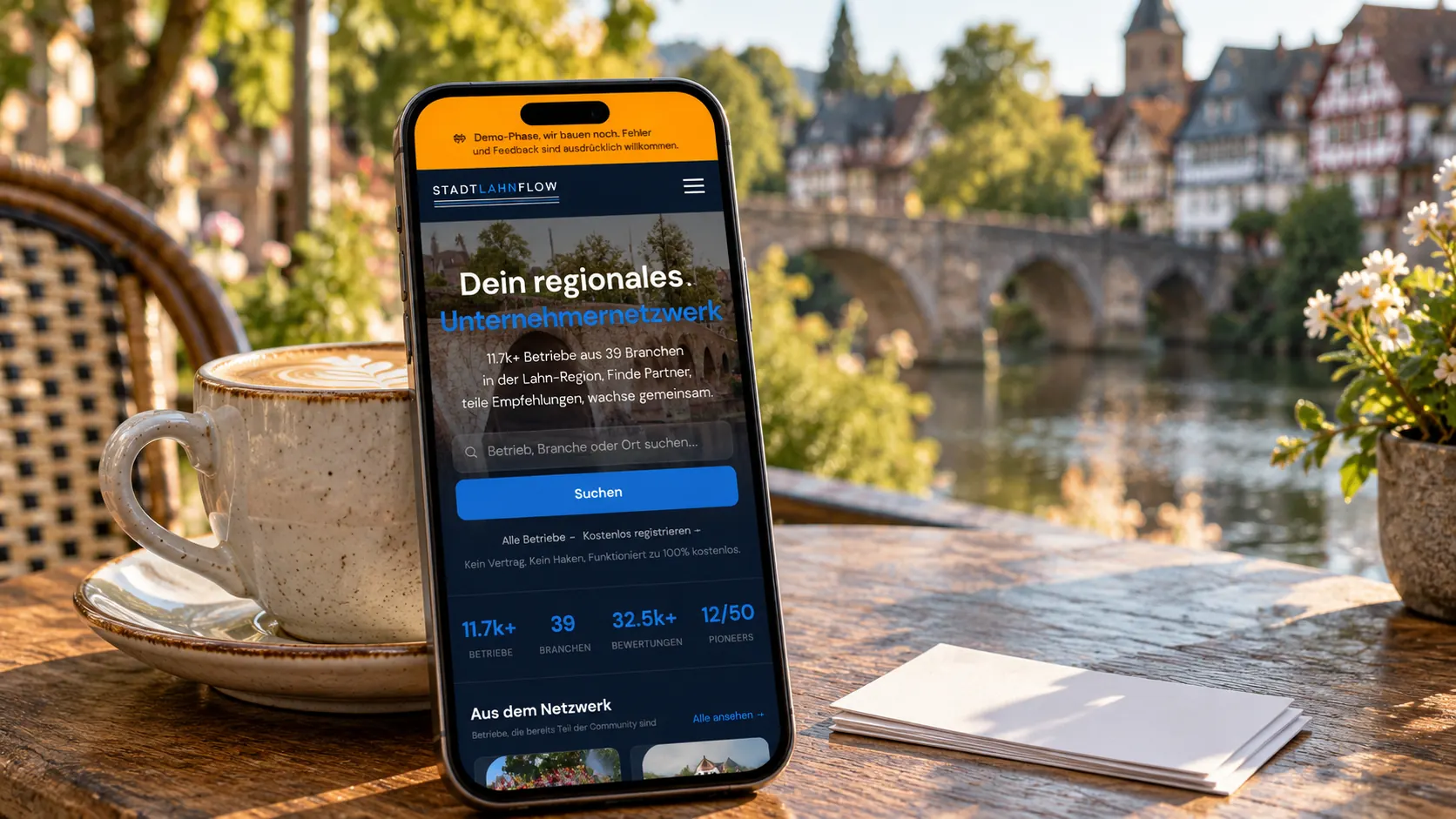Smartphone mit Stadt Lahn Flow auf einem Cafétisch in einer Altstadt an der Lahn